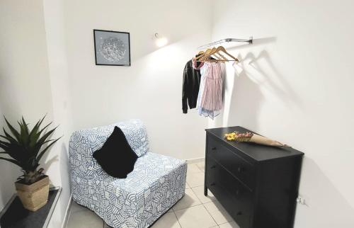 a living room with a chair and a dresser at B & B LuVì in Vibo Valentia