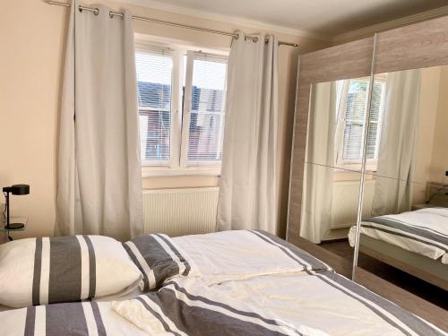 ein Schlafzimmer mit einem Bett und zwei Fenstern in der Unterkunft Turmresidenz 6 KaMare - 300m zum Strand in Scharbeutz