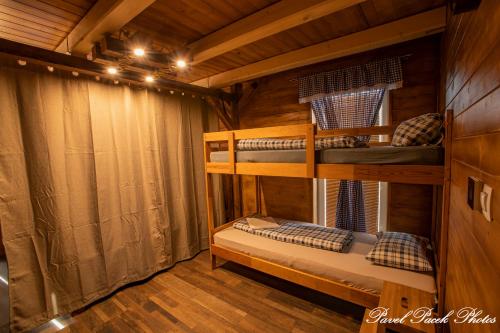 a room with two bunk beds in a cabin at Penzion Kera in Rossitz