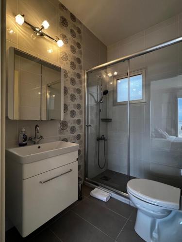 a bathroom with a shower and a sink and a toilet at True front line apartment in Tatlisu North Cyprus in Küçükerenköy