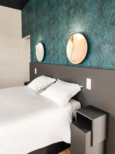a bedroom with a bed and two mirrors on the wall at Maison Toussaint in Saint-Laurent-sur-Sèvre