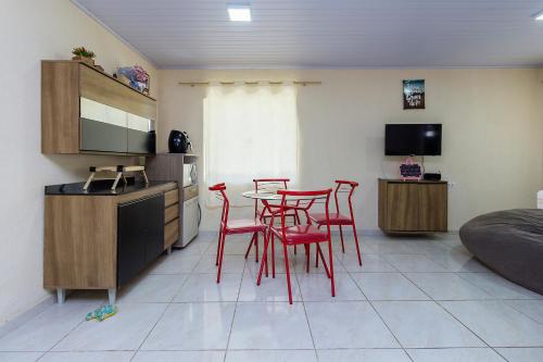 a kitchen with red chairs and a table in a room at Sobrado da Vila, 1km Centro, ideal Trabalho e Passeio in Morretes