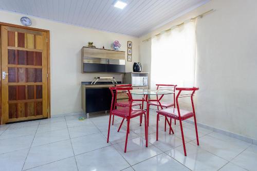 a kitchen with red chairs and a table in a room at Sobrado da Vila, 1km Centro, ideal Trabalho e Passeio in Morretes