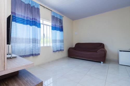 a living room with a couch and a tv at Sobrado da Vila, 1km Centro, ideal Trabalho e Passeio in Morretes