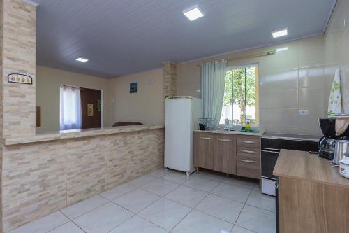 a large kitchen with a refrigerator and a sink at Sobrado da Vila, 1km Centro, ideal Trabalho e Passeio in Morretes