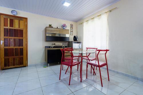 a kitchen with red chairs and a table in a room at Sobrado da Vila, 1km Centro, ideal Trabalho e Passeio in Morretes