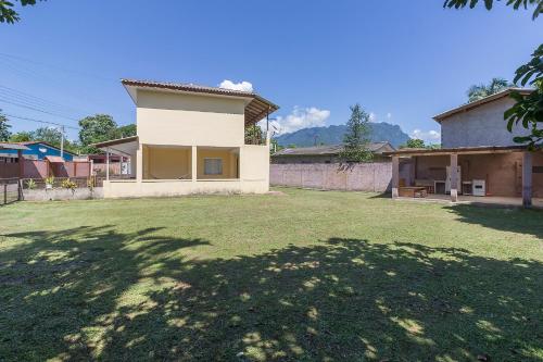 a house with a large yard in front of it at Sobrado da Vila, 1km Centro, ideal Trabalho e Passeio in Morretes