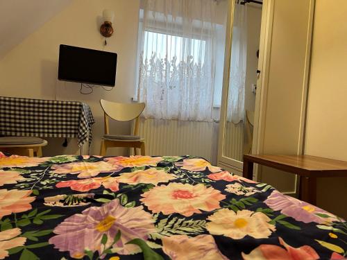 a bedroom with a bed with a floral comforter at Noclegi u Emilii in Sopot