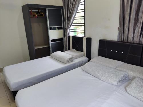 - une chambre avec 2 lits et une fenêtre dans l'établissement HK68 Desaru homestay, à Kangkar Chemaran