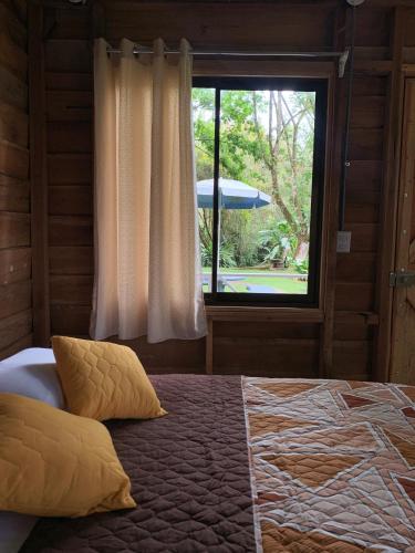a bedroom with a large bed with a window at Hospedaje La Naciente in Turrialba