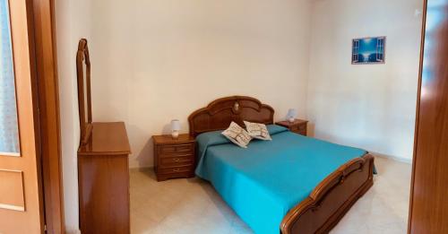 1 dormitorio con cama azul y cabecero de madera en Casamare en Maiori