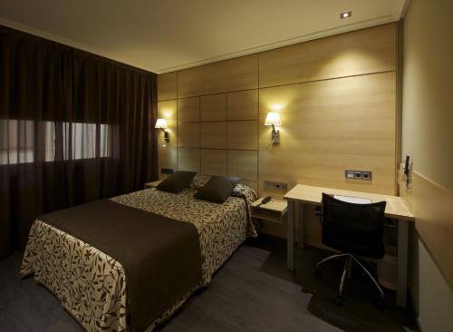 a hotel room with a bed and a desk with a computer at Hotel Francisco II in Ourense