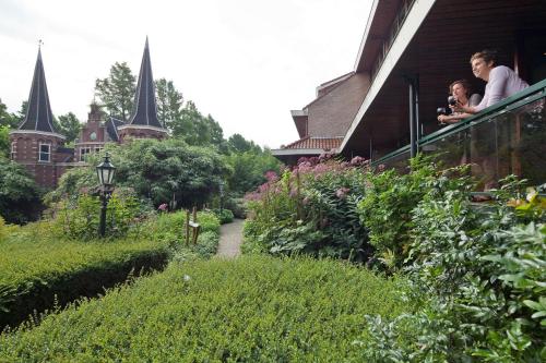 a woman and child on a balcony of a house at Van der Valk Hotel Avifauna in Alphen aan den Rijn