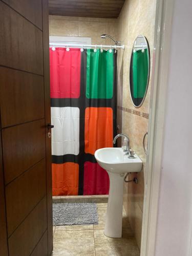baño con cortina de ducha colorida y lavamanos en Alojamiento Peumayen II en Trenque Lauquen