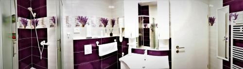 El baño incluye aseo y está decorado en tonos púrpura y blanco. en Apartmani Peyton, en Slavonski Brod
