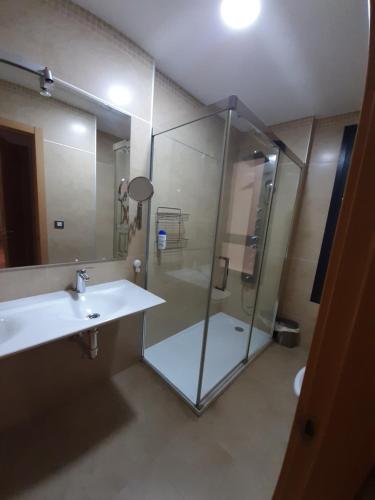 La salle de bains est pourvue d'une douche, d'un lavabo et d'un miroir. dans l'établissement LUCIA S HOUSE, à Mairena del Aljarafe