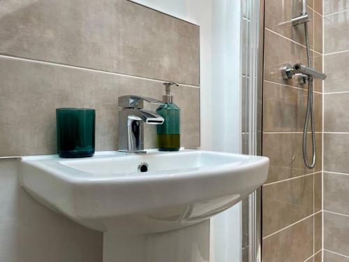 a white sink in a bathroom with a shower at Big Modern House - 15min to NEC - Sleeps 10 in Birmingham