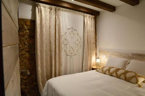 a bedroom with a white bed and a curtain at Can Senio 1 in Tossa de Mar