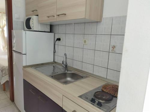 a kitchen with a sink and a refrigerator at apartmani Natali in Podaca