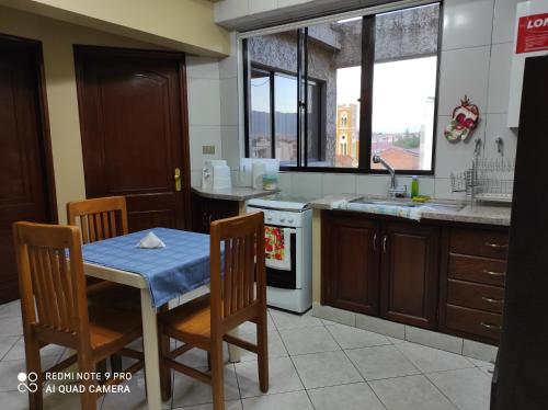 una cocina con mesa y mantel azul. en Departamento Frente a la Plaza Sucre de Tarija, wifi, ascensor, garaje extra, en Tarija
