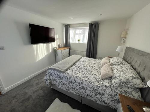 a bedroom with a bed and a flat screen tv at The Nest in Keynsham
