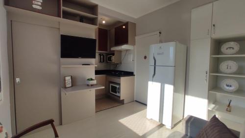 uma cozinha com um frigorífico branco e um fogão em Cidade Baixa Apart Studio Encantador em Porto Alegre