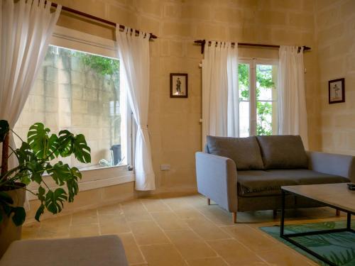 a living room with a couch and a window at Il Gnejna in Xagħra