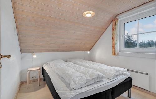 a bed in a small room with a window at Cozy Home In Blvand With Sauna in Blåvand