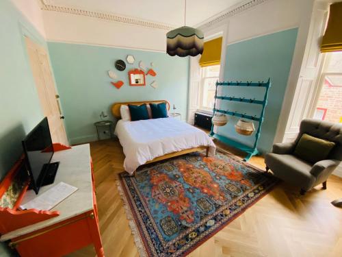 a bedroom with a bed and a chair and a rug at Ben A'an House in Callander