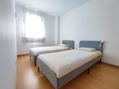 two beds in a room with a window at Apartment near airport & citycenter Free Parking in Lisbon