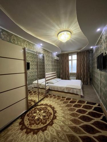 1 dormitorio con cama y espejo en Karabolo, en Dushanbe