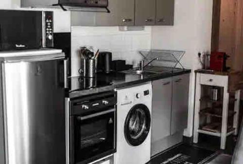 a kitchen with a stove and a washer and dryer at Patio Arena in Bayonne
