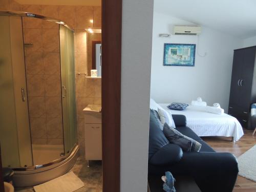 a room with a bed and a glass shower at Apartments Nika in Podstrana