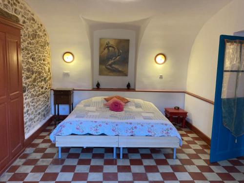Saint-Florent-sur-AuzonnetにあるCharmant logement dans les Cevennesのベッドルーム1室(ピンクの帽子付きのベッド1台付)