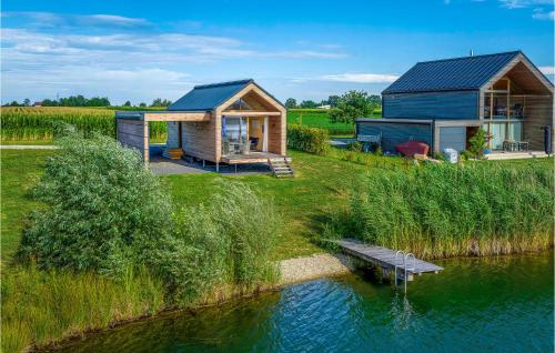 a house on the side of a river with a dock at Ferienhaus Am Naturbadesee in Königsdorf
