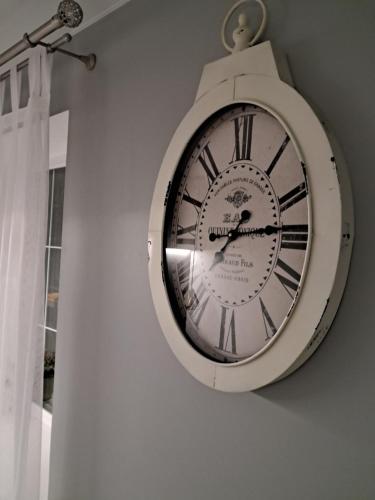 a clock hanging on the side of a wall at super apartment on O.Polya 137 in Dnipro