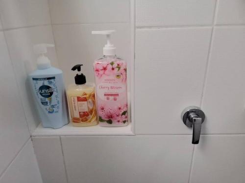 a bathroom shelf with two bottles of soap and cosmetics at SkyView in Johor Bahru