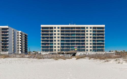 a large building on the beach next to the sand at Island Winds East by Brett Robinson Vacations in Gulf Shores