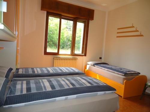 two beds in a room with a window at Villa Tiziana Typ T4 in Crone