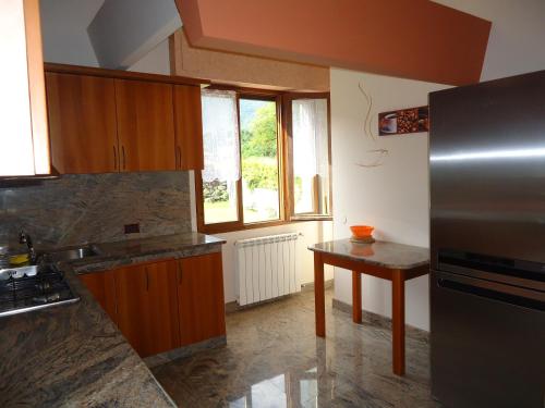 a kitchen with a stainless steel refrigerator and a table at Villa Tiziana Typ T4 in Crone