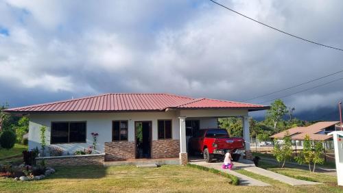 a little girl standing in front of a small house at Vistaverdeboquete in Boquete