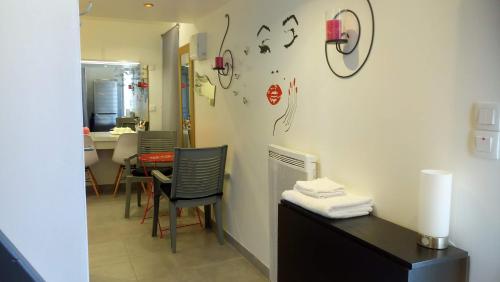 a room with a table and chairs and a clock on the wall at Dépendance privée avec entrée autonome in Toulouse