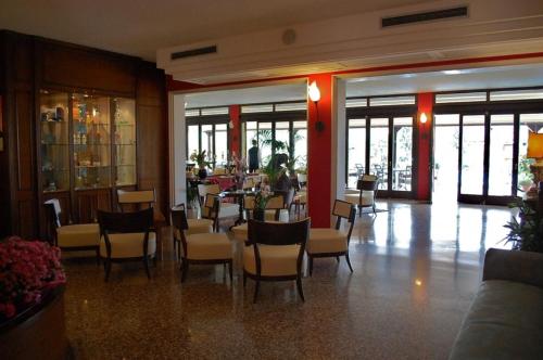 a restaurant with chairs and tables in a building at Villa Madrina Lovely and Dynamic Hotel in Garda