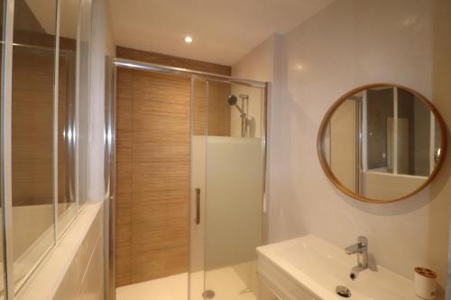 une salle de bain avec une douche, un lavabo et un miroir dans l'établissement Appartement au calme plein centre historique, à Montpellier