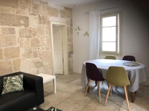 une salle à manger avec une table et des chaises blanches dans l'établissement Appartement au calme plein centre historique, à Montpellier