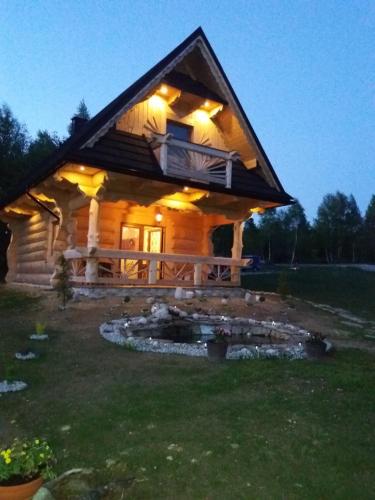 una cabaña de madera con una hoguera en el patio en Domek Jurgów 406, en Jurgów