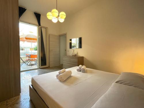 una camera da letto con un letto e asciugamani di Casa Palma a 100 passi dal mare a Marina di Ragusa