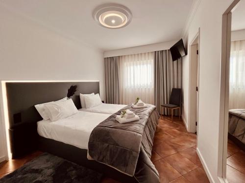 a hotel room with a bed with towels on it at BHDouro in Baião