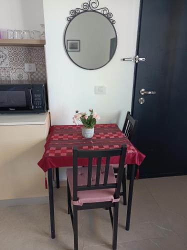 a table with a red table cloth and two chairs and a mirror at זוהר במדבר ים המלח in Neve Zohar