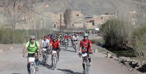a large group of people riding bikes down a road at Auberge restaurant Afoud in Agoudal